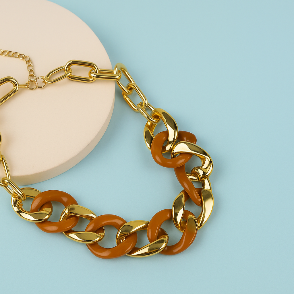 Gold and brown chain bracelet on a light blue background