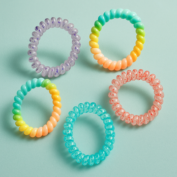 Set of colorful spiral hair ties on a light blue background