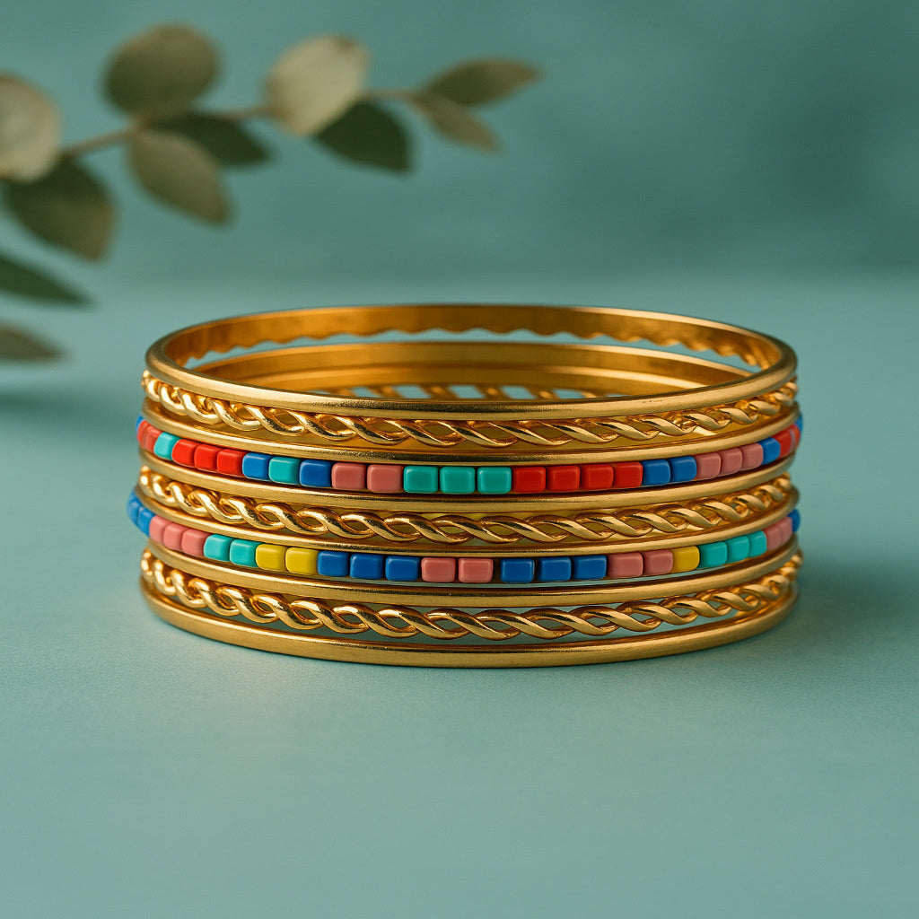 Stack of gold bangles with colorful beads on a teal background
