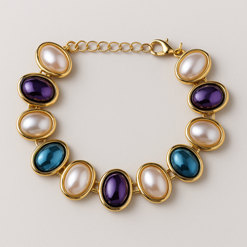 Gold bracelet with colorful gemstones on a light background