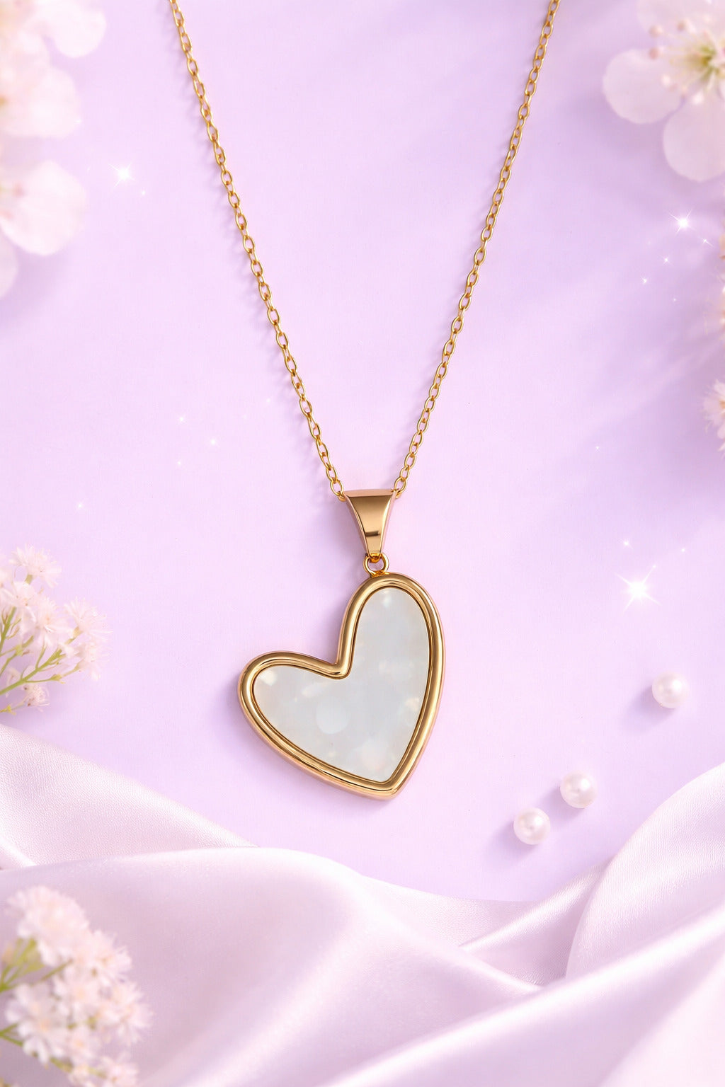 Heart-shaped pendant necklace with gold frame on a light purple fabric background