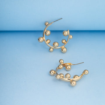 Gold hoop earrings on a blue background