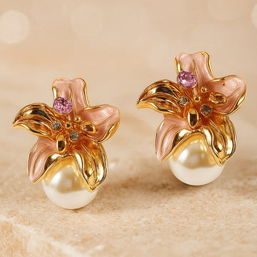 Gold flower earrings with pearls and gemstones on a beige background