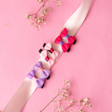 A collection of printed hair bows and pins clips in various colors including pink, purple, and black, 