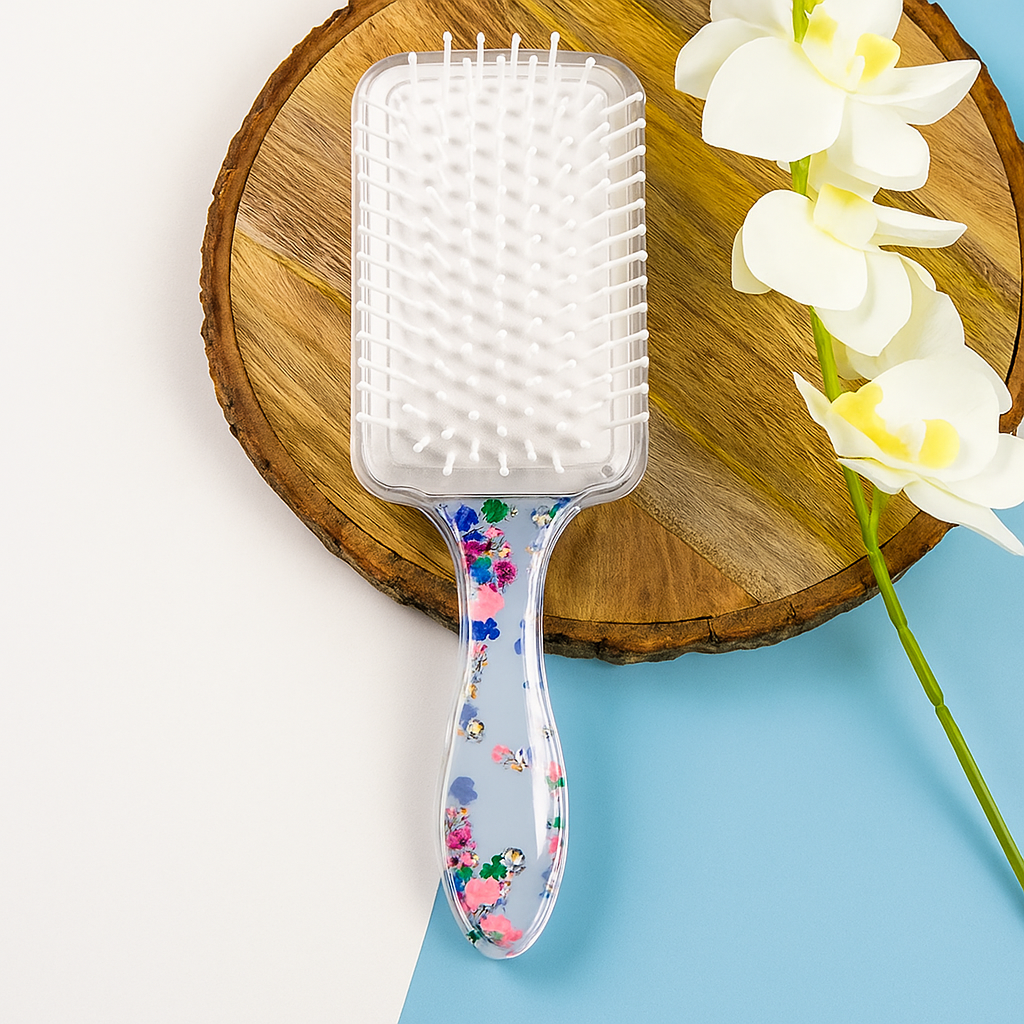 Hairbrush with floral handle on a wooden block with flowers