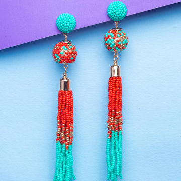 Colorful beaded earrings on a blue and purple gradient background