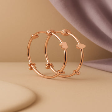 Rose gold hoop earrings on a beige background
