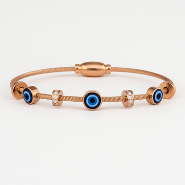 Rose gold bracelet with blue evil eye charms on a white background