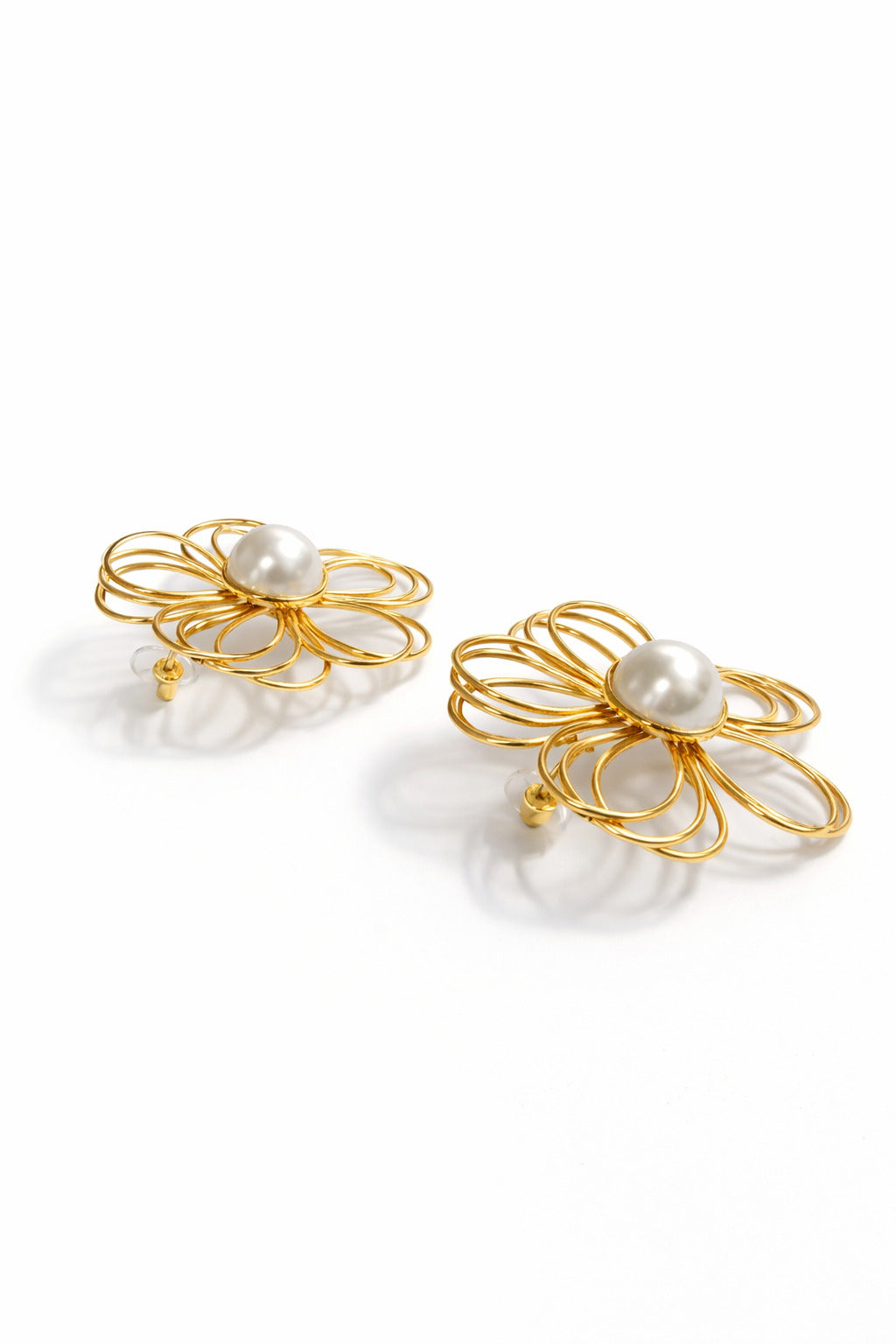 Gold flower-shaped earrings with pearl centers on a white background