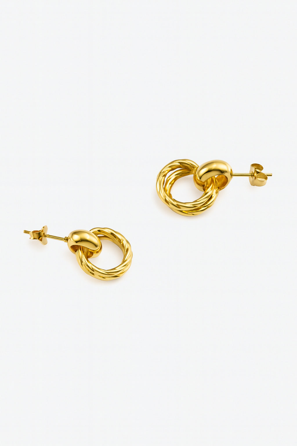 Gold knot earrings on a white background