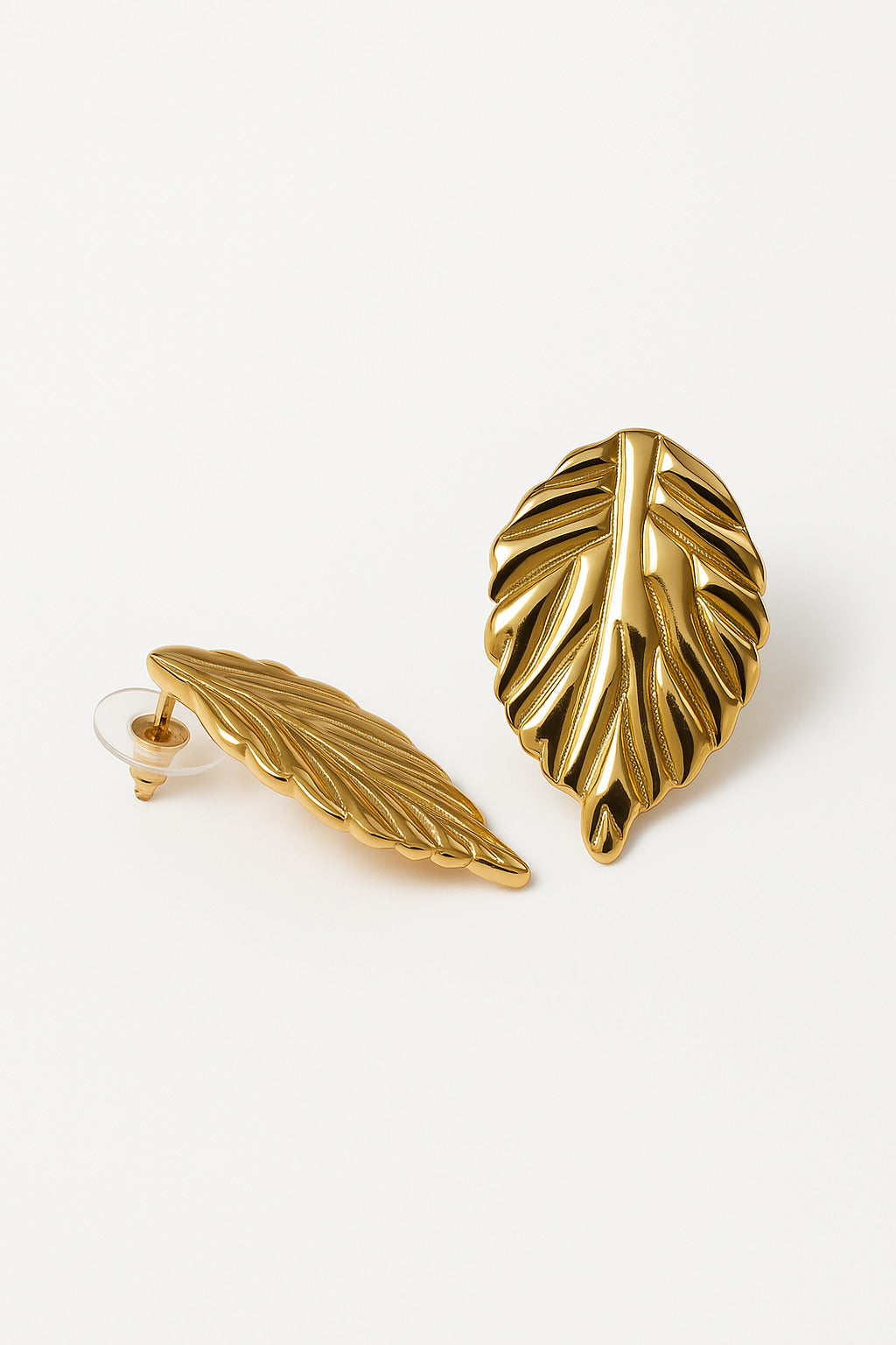 Gold leaf-shaped earrings on a white background