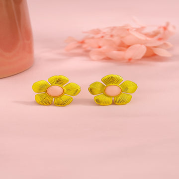 Yellow flower-shaped earrings on a pink background