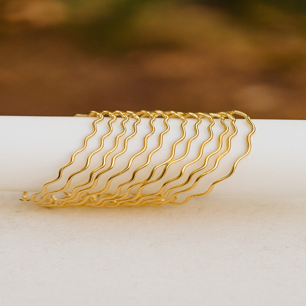 Set of gold hair clips on a white surface with a blurred background