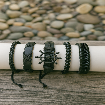 Set of black braided bracelets on a white cylindrical object with a stone background