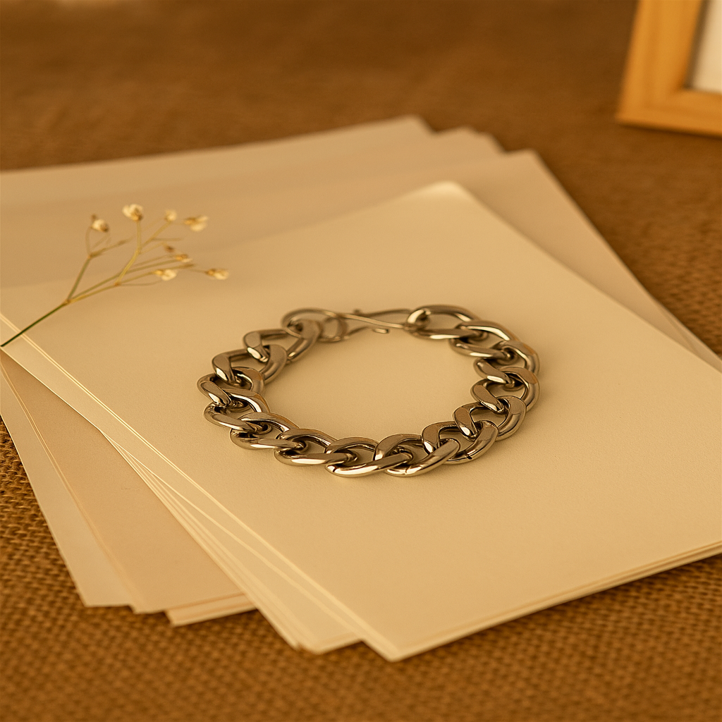 Silver chain bracelet on a stack of beige cards with a blurred background