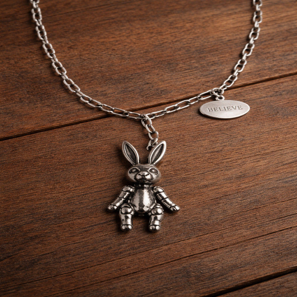 Silver rabbit pendant necklace on a wooden surface