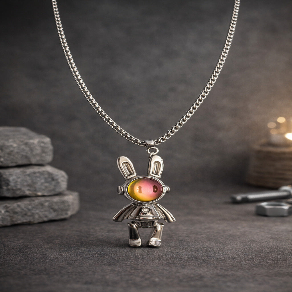 Silver pendant shaped like a rabbit with a colorful gem on a dark surface
