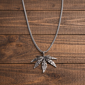 Silver leaf pendant necklace on a wooden surface