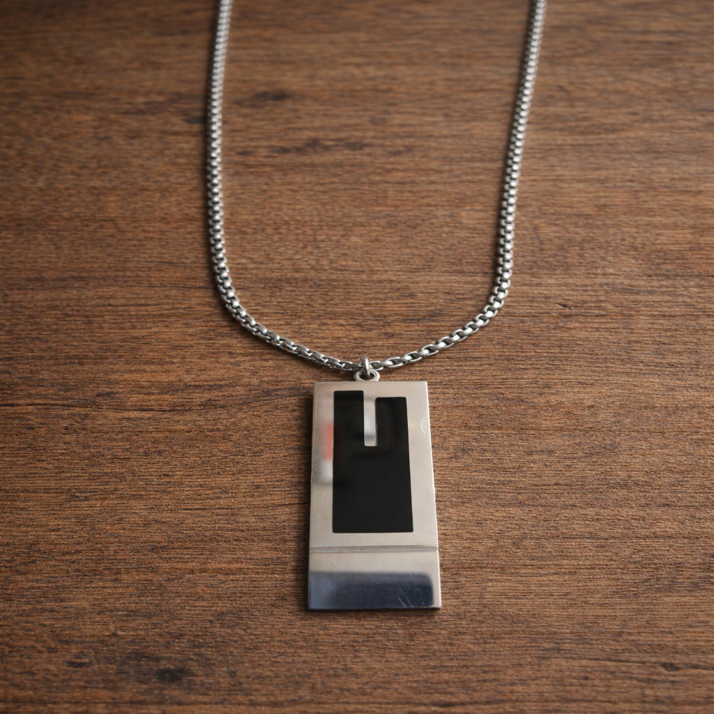 Necklace with a rectangular pendant on a wooden surface