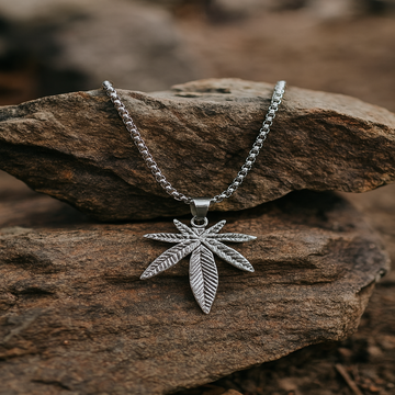 Silver leaf pendant necklace on a rock with a natural background