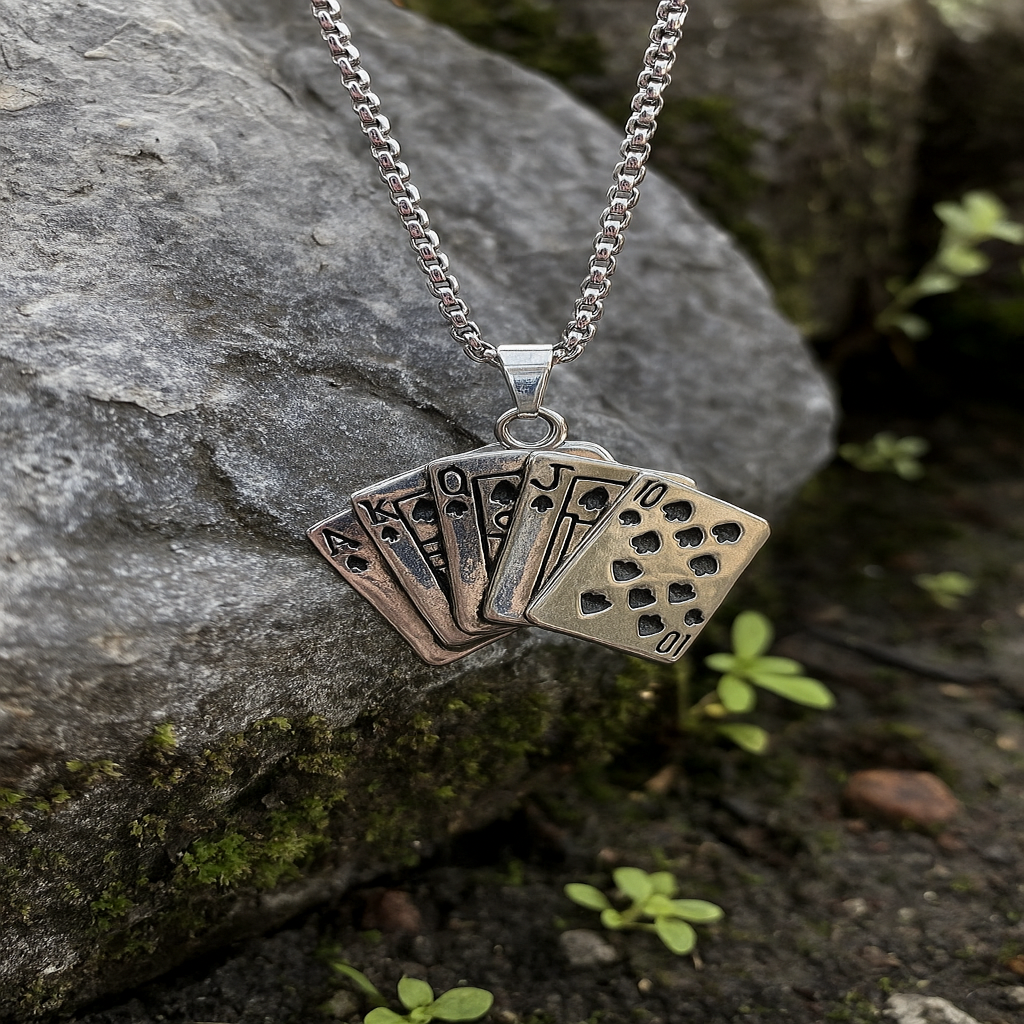 Silver necklace with a card suit pendant on a stone surface