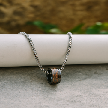 Necklace with a wooden pendant on a stone surface