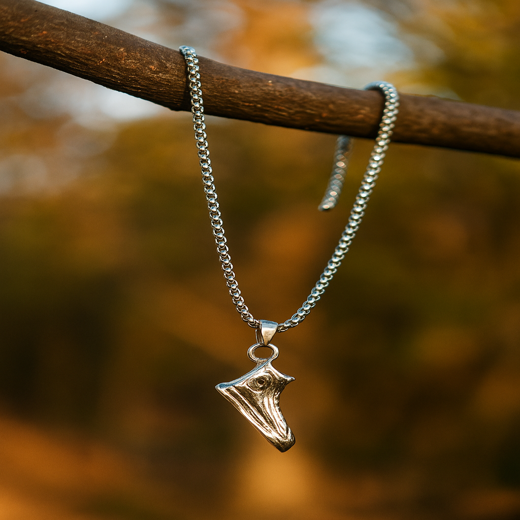 Silver necklace with a shark tooth pendant on a blurred natural background