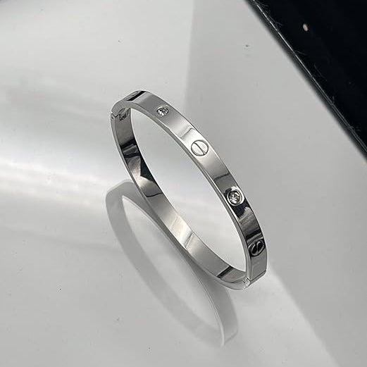 Silver bracelet with diamond accents on a reflective surface