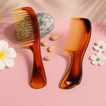 Two tortoiseshell combs on a pink background with flowers and stones.