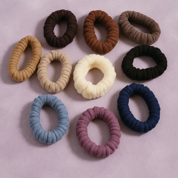 Assorted colorful scrunchies on a light pink background
