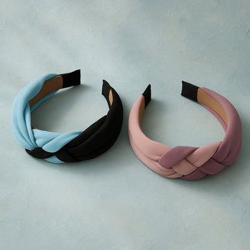Two headbands, one blue and black, the other pink and black, on a light gray background.