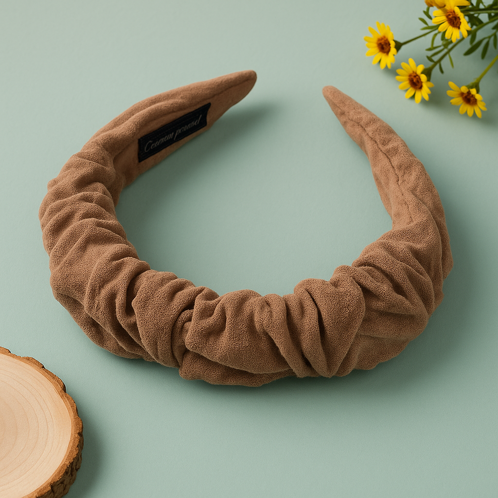 Brown headband with a label on a light green background with flowers and wood slice.