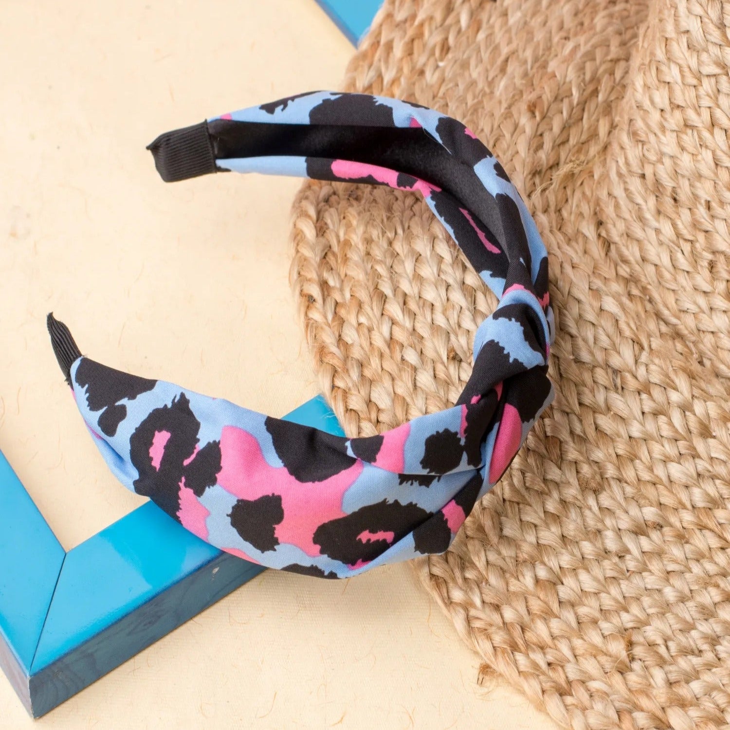 A multicolored velvet headband with a top knot detail, displayed on a neutral background.