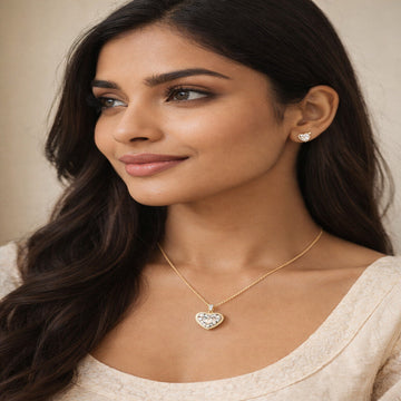 Woman wearing a heart-shaped necklace and earrings against a neutral background