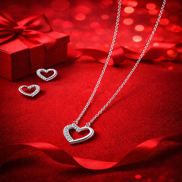 Heart-shaped jewelry set on a red background with a gift box.